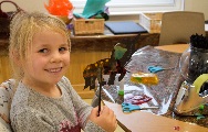 a little girl shows off a unicorn shadow puppet created in one of our craft sessions